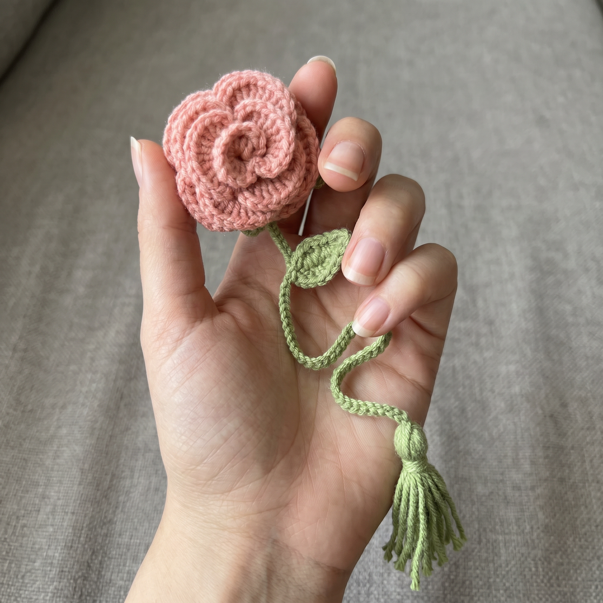 Pink Rose Crochet Bookmark held in hand to show scale
