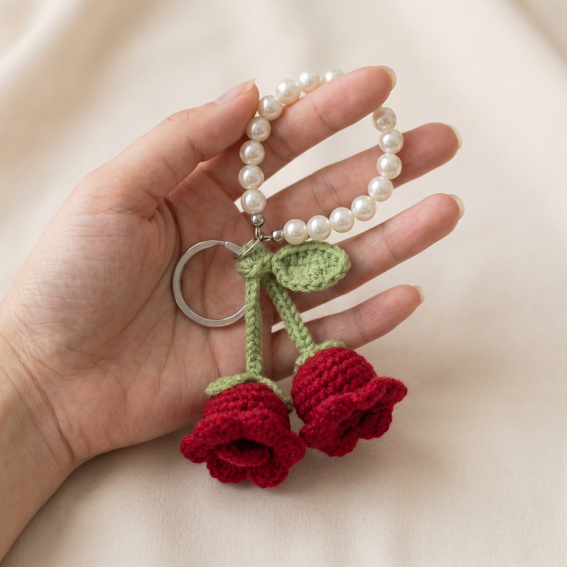 Twin Rose Pearl Crochet Keychain held in hand to show scale