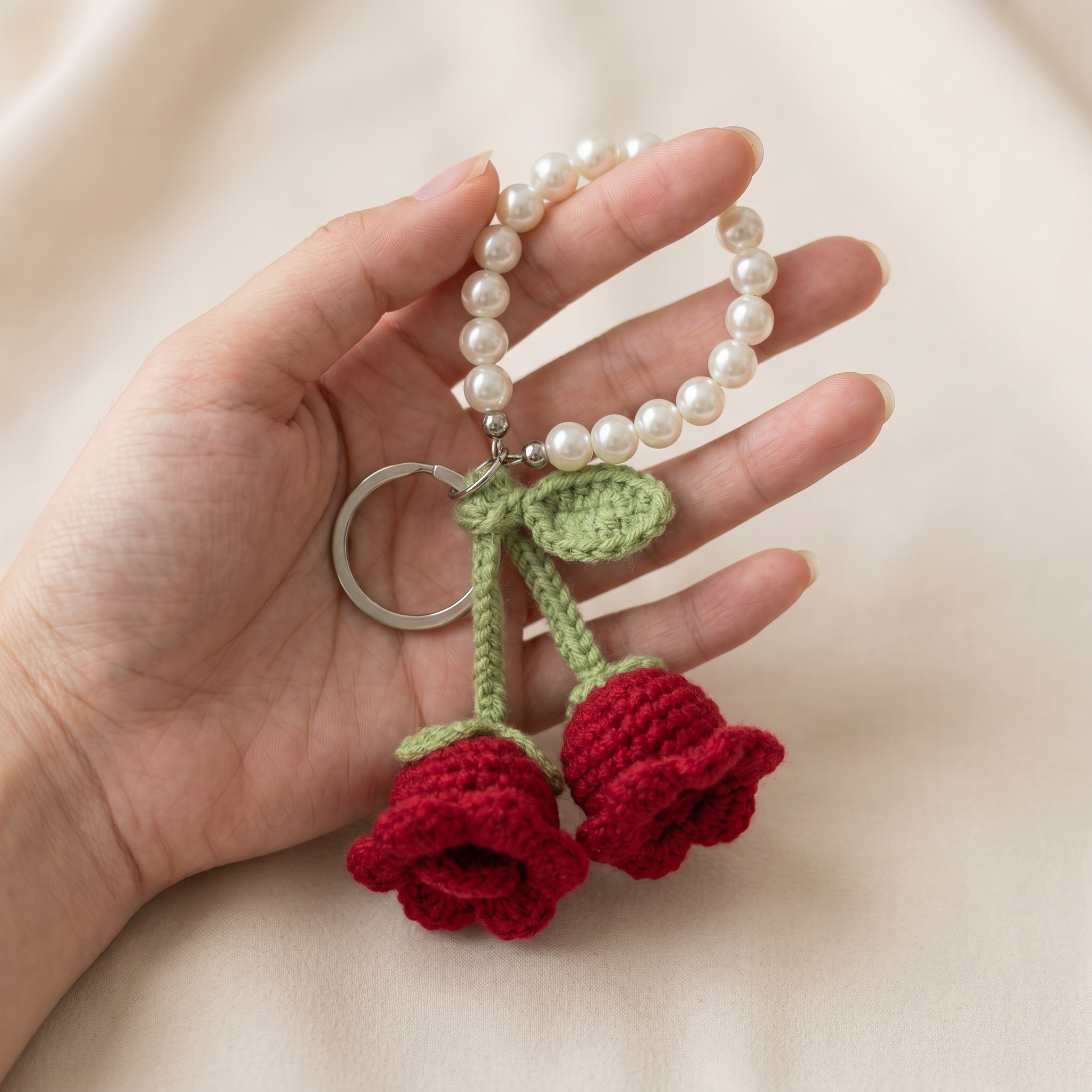 Twin Rose Pearl Crochet Keychain held in hand to show scale