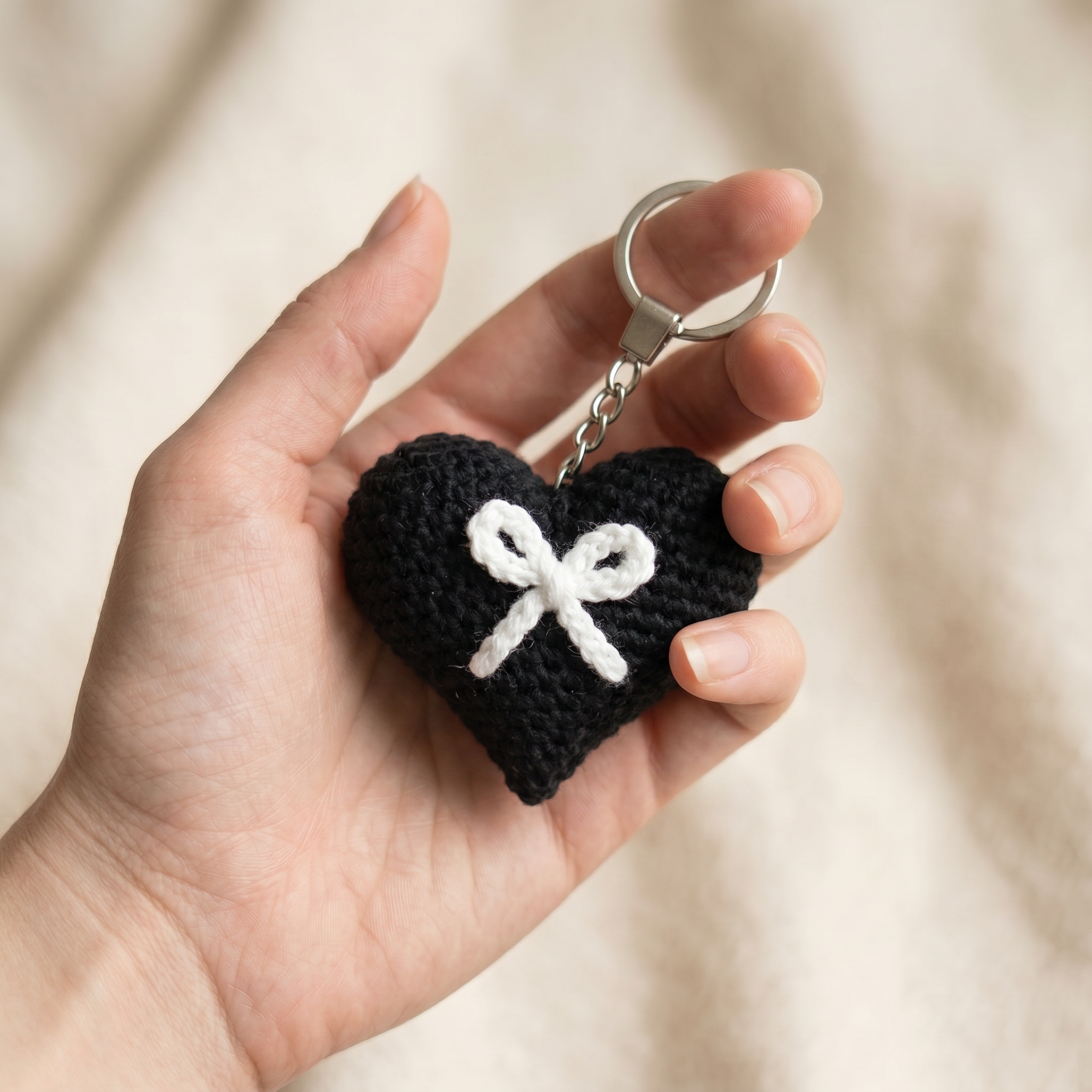 White Bow Heart Crochet Keychain held in hand to show scale