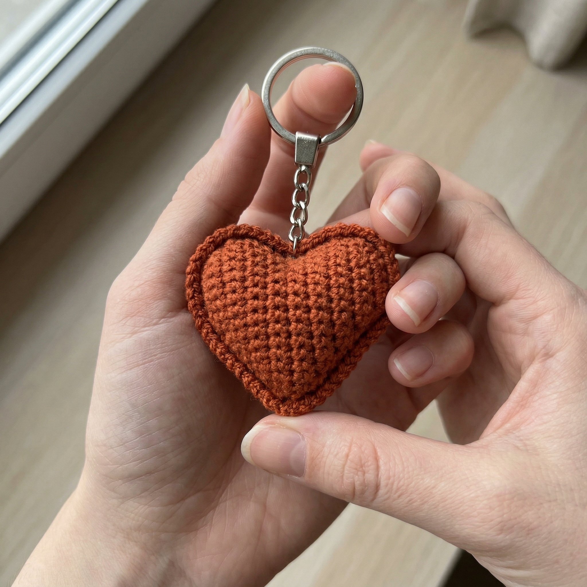 Amber Heart Crochet Keychain held in hand to show scale