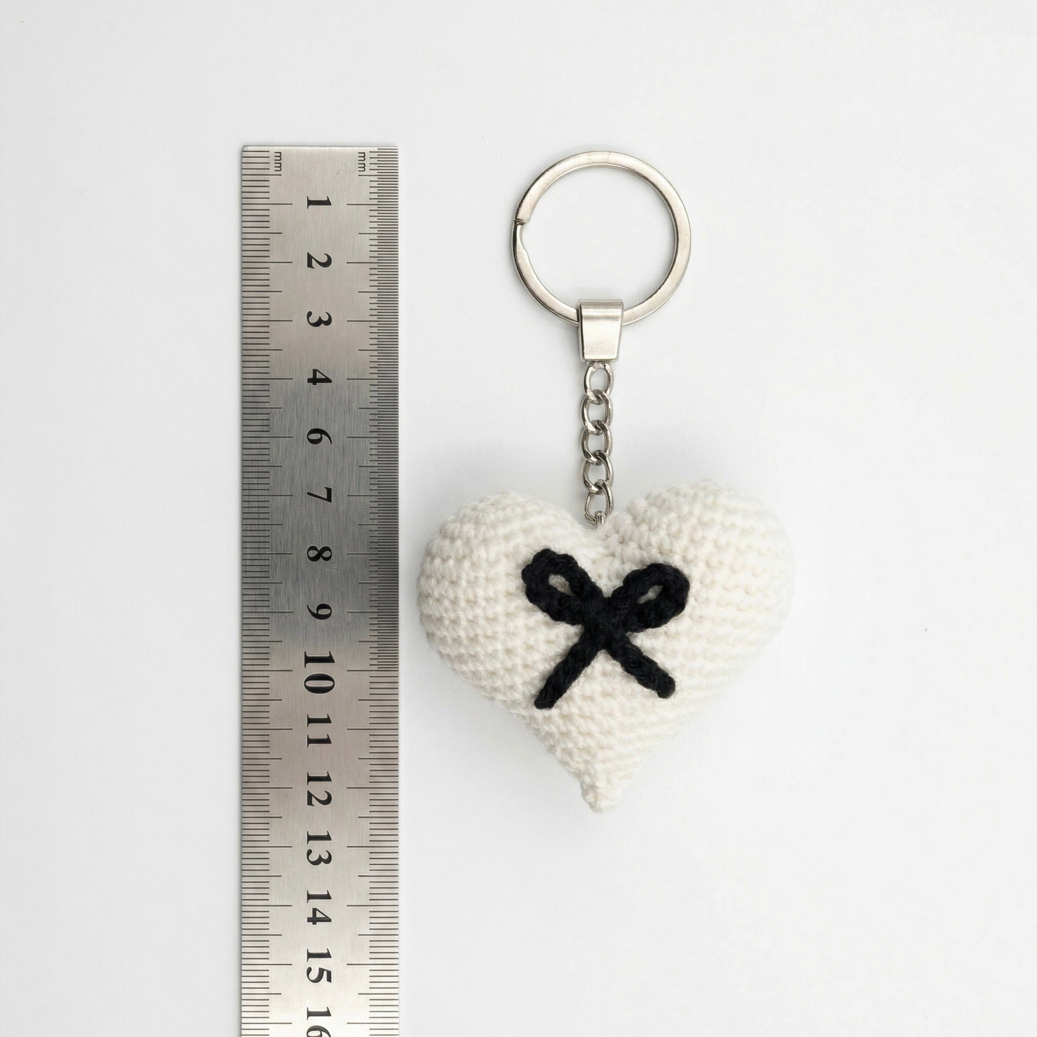 Black Bow Heart Crochet Keychain with a size reference