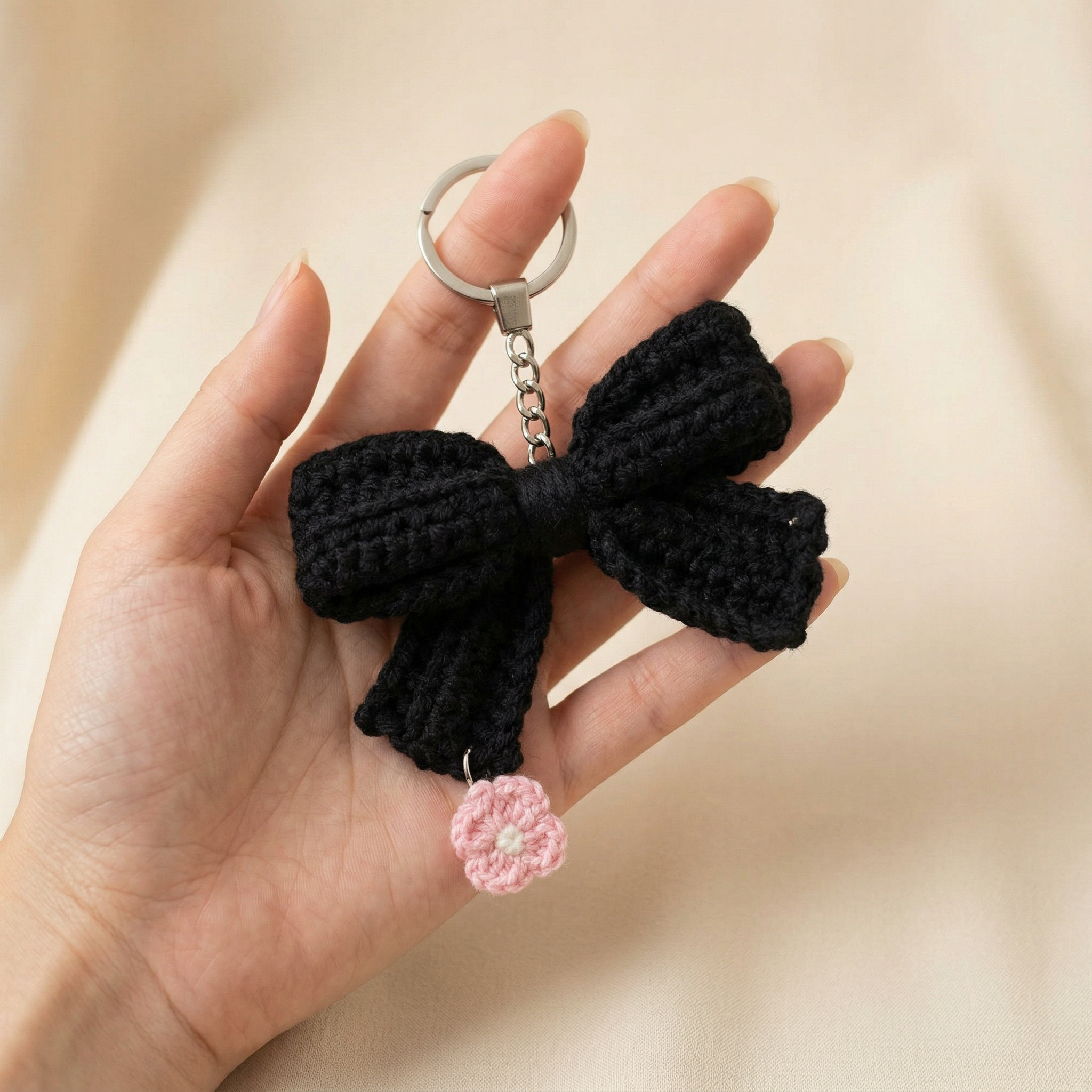Black Bow Crochet Keychain held in hand to show scale